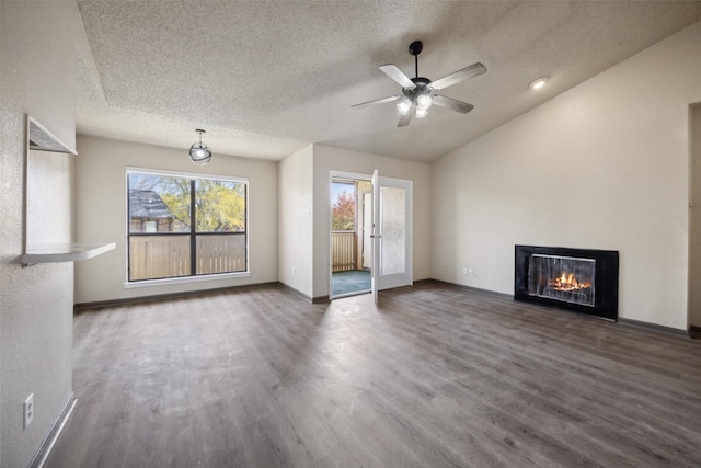 unfurnished living room with a textured ceiling, ceiling fan, dark wood-type flooring, and vaulted ceiling