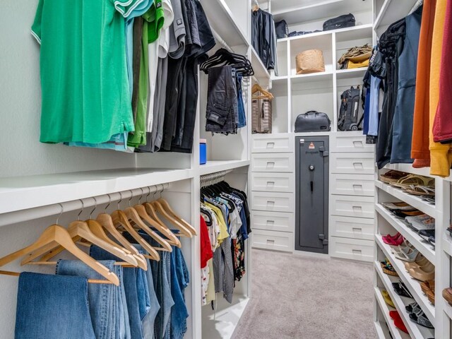 walk in closet featuring light carpet