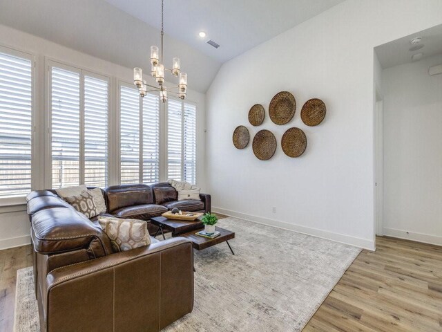 kitchen with pendant lighting, light hardwood / wood-style flooring, appliances with stainless steel finishes, dark stone countertops, and a kitchen island