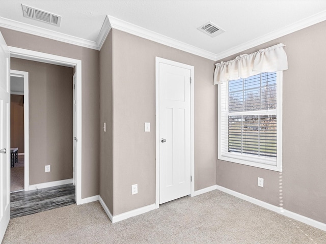 unfurnished bedroom featuring carpet floors and crown molding