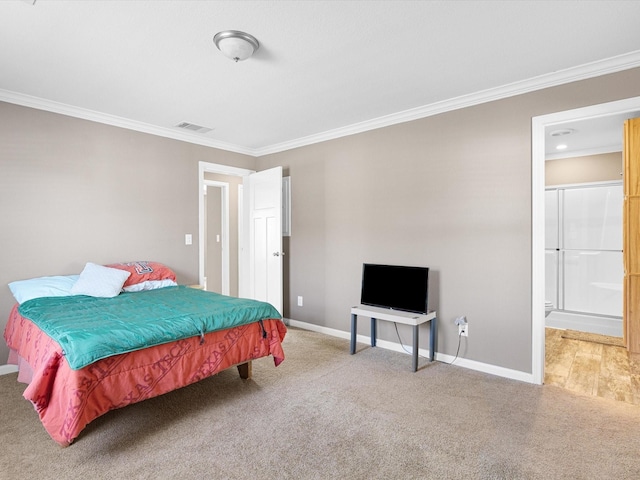 bedroom with ornamental molding, ensuite bathroom, and carpet