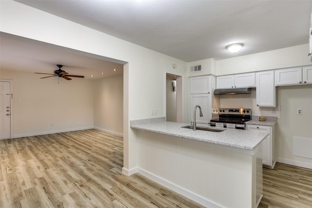 kitchen with sink, light stone counters, stainless steel electric range, light wood-type flooring, and white cabinets