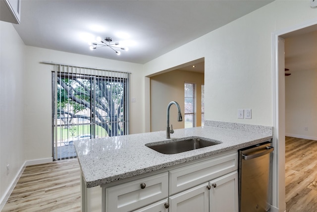 kitchen featuring white cabinets, sink, stainless steel dishwasher, light stone countertops, and kitchen peninsula