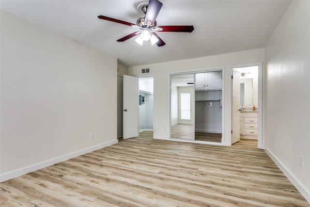 unfurnished bedroom featuring ensuite bathroom, ceiling fan, light hardwood / wood-style floors, and a closet