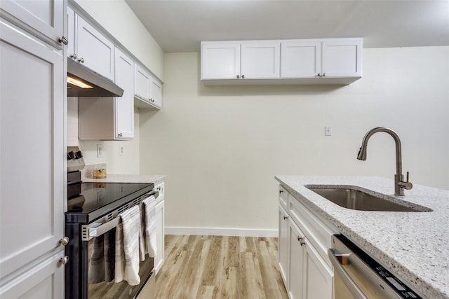 kitchen featuring stainless steel appliances, light stone countertops, sink, and white cabinets