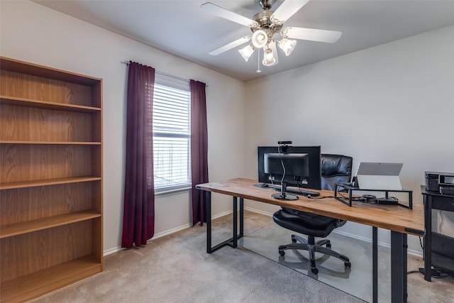 carpeted home office featuring ceiling fan