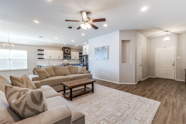 living room featuring sink, ceiling fan with notable chandelier, and light hardwood / wood-style flooring