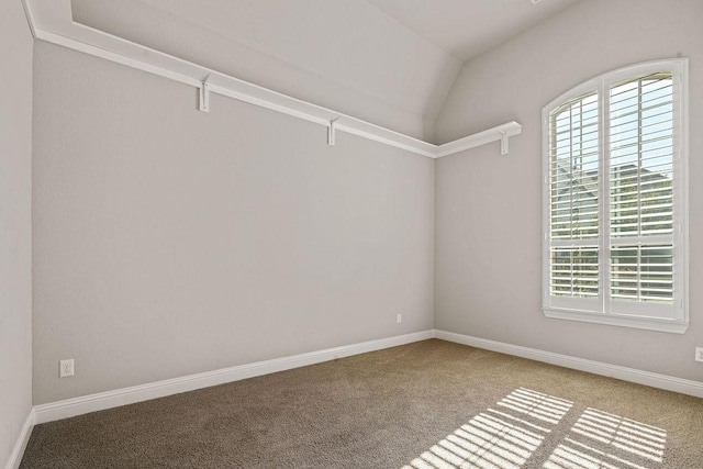 carpeted empty room with vaulted ceiling