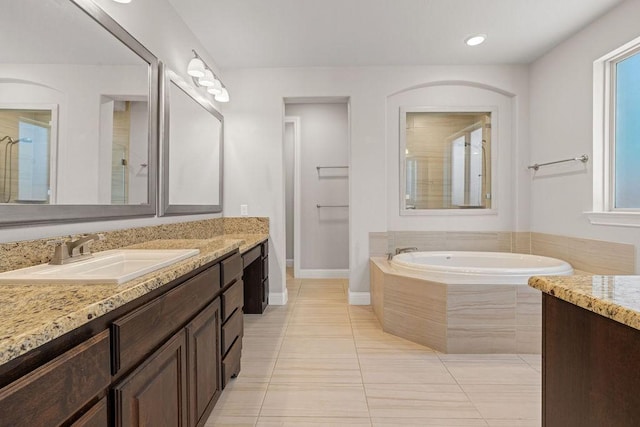 bathroom with vanity, tiled bath, and tile patterned floors