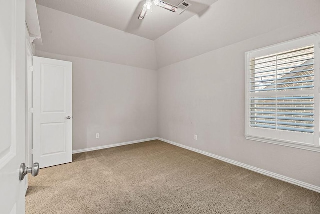 empty room with light colored carpet and vaulted ceiling