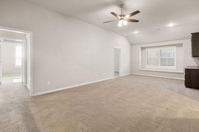 unfurnished living room featuring lofted ceiling, light carpet, and a wealth of natural light