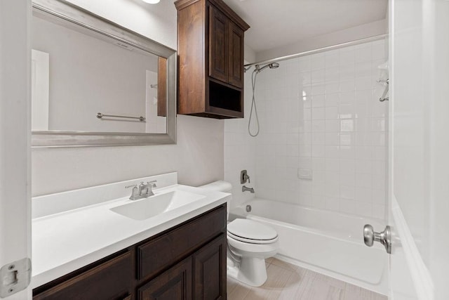 full bathroom with tile patterned floors, vanity, tiled shower / bath combo, and toilet