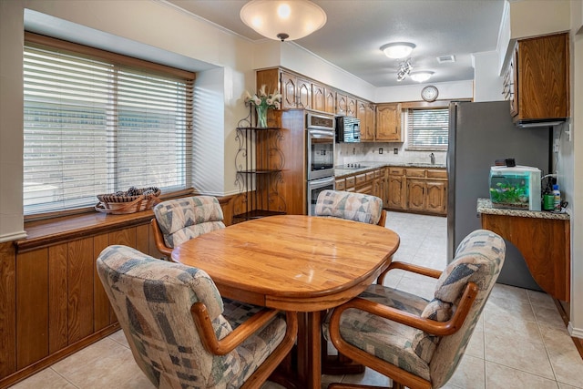 tiled dining area with crown molding and sink