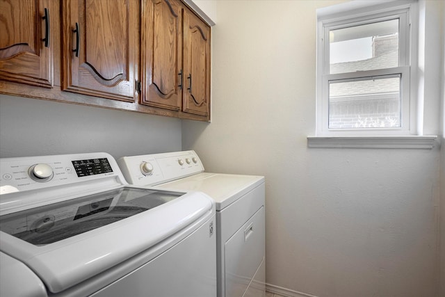 clothes washing area featuring cabinets and independent washer and dryer