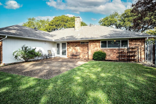 rear view of property with a yard and a patio area