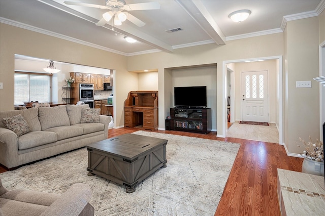 living room with beamed ceiling, ceiling fan, crown molding, and light wood-type flooring