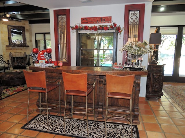 bar with tile patterned floors and a fireplace