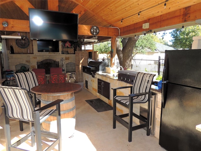 view of patio featuring a gazebo, an outdoor kitchen, a grill, and an outdoor bar