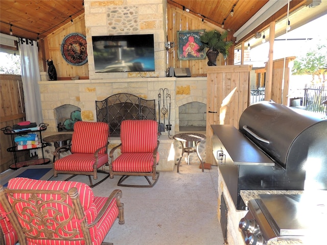 view of patio with a stone fireplace and area for grilling