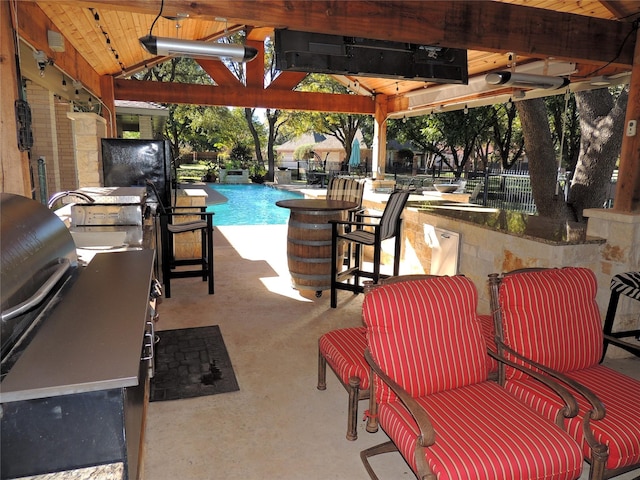 view of patio / terrace featuring exterior kitchen, a gazebo, and a bar