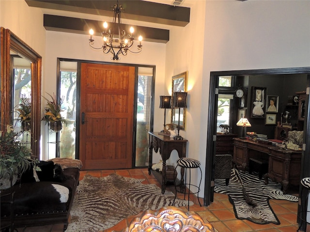 tiled entryway featuring an inviting chandelier