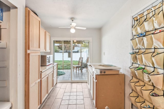 kitchen featuring ceiling fan and light brown cabinetry