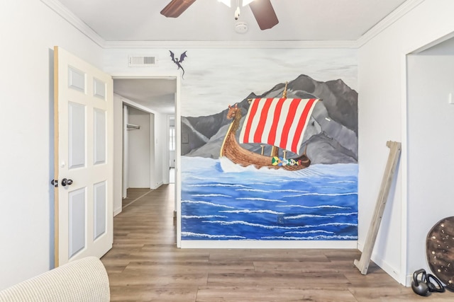 bedroom featuring hardwood / wood-style flooring, ceiling fan, and crown molding