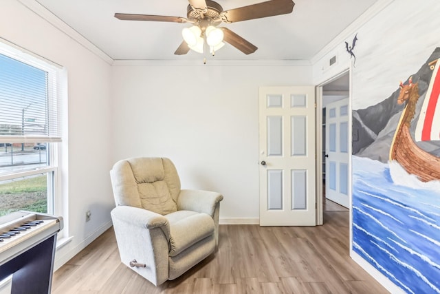 sitting room featuring light hardwood / wood-style floors, ceiling fan, and crown molding