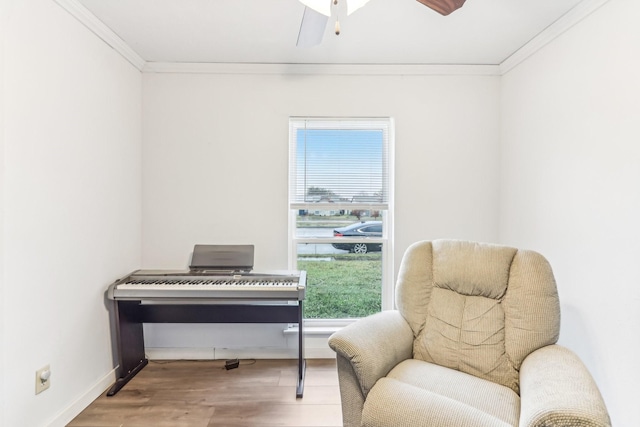 living area with crown molding and wood-type flooring