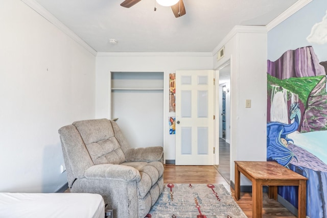 living area featuring ceiling fan, crown molding, and hardwood / wood-style flooring