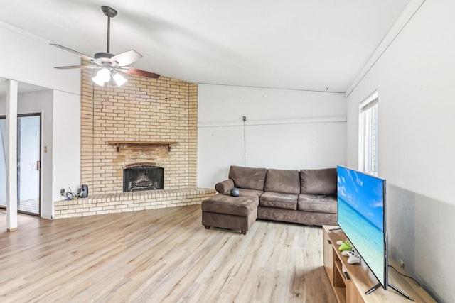 living room with a fireplace, light hardwood / wood-style floors, ceiling fan, and crown molding