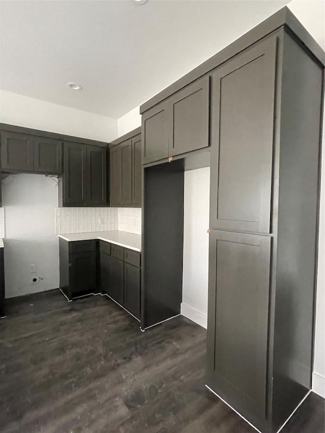 kitchen featuring decorative backsplash, gray cabinets, and dark wood-type flooring