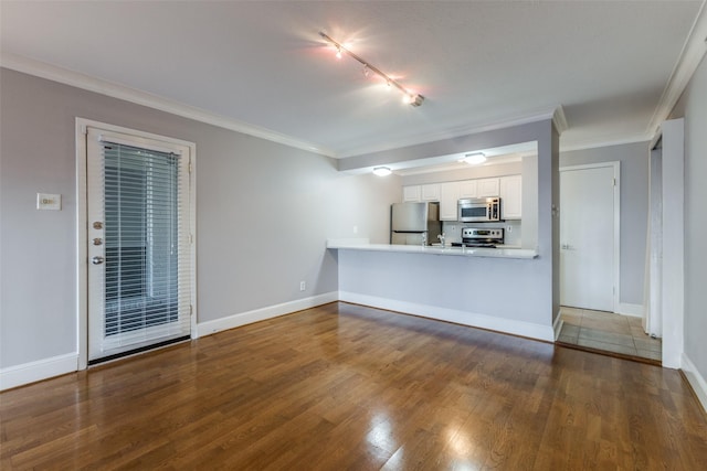 unfurnished living room with crown molding, wood-type flooring, and track lighting