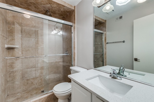 bathroom with vanity, toilet, and a shower with door