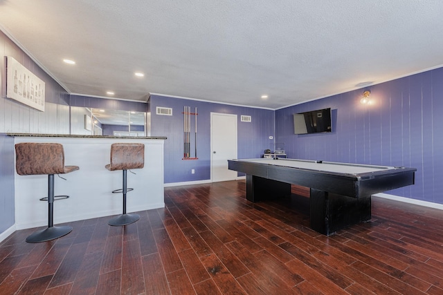 recreation room featuring wood walls, dark hardwood / wood-style flooring, a textured ceiling, and pool table