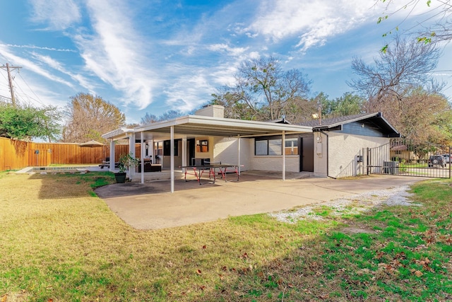 rear view of house featuring a yard and a patio area