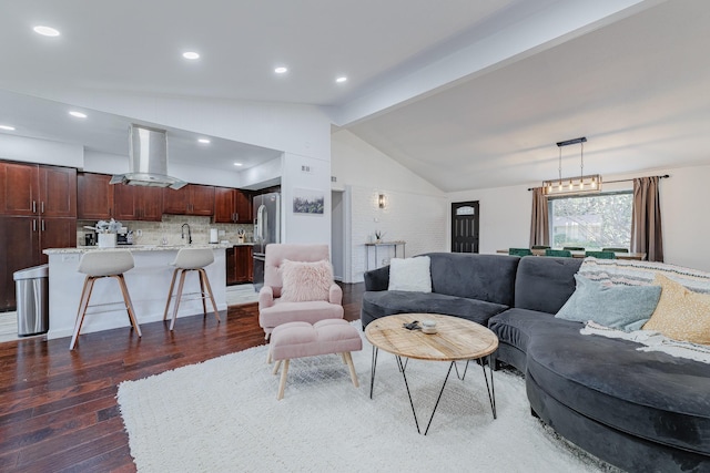 living room featuring dark hardwood / wood-style flooring, vaulted ceiling with beams, and sink