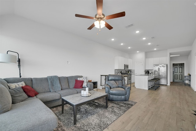 living room featuring light wood-type flooring and ceiling fan