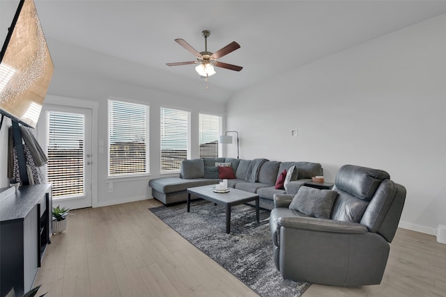 living room with a wealth of natural light, light hardwood / wood-style flooring, ceiling fan, and lofted ceiling