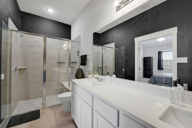 bathroom featuring tile patterned floors, vanity, toilet, and a shower with shower door