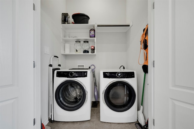 clothes washing area with washer and clothes dryer and light tile patterned floors