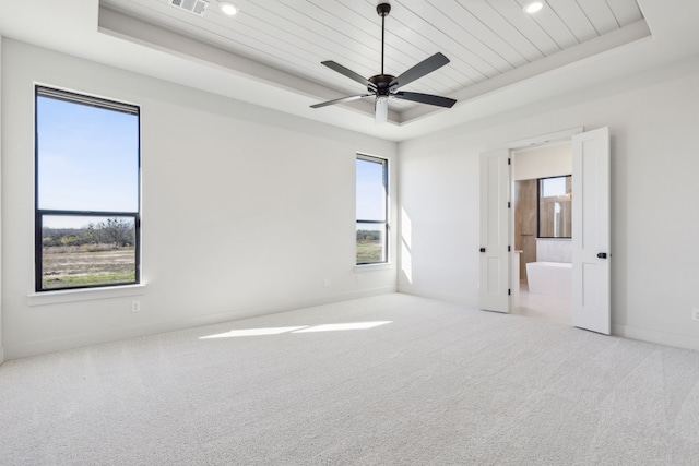 carpeted empty room with ceiling fan, a healthy amount of sunlight, a raised ceiling, and wooden ceiling