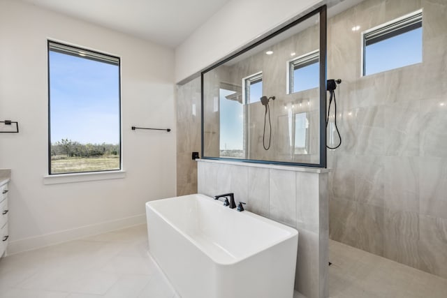 bathroom with a wealth of natural light, tile patterned flooring, vanity, and plus walk in shower