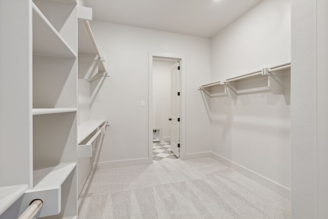 walk in closet with light colored carpet