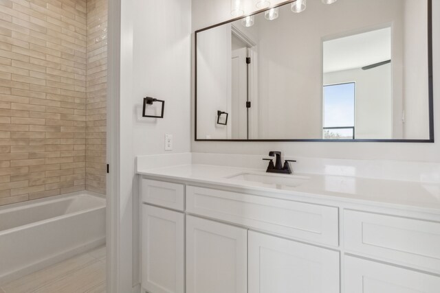 bathroom featuring vanity and tiled shower / bath