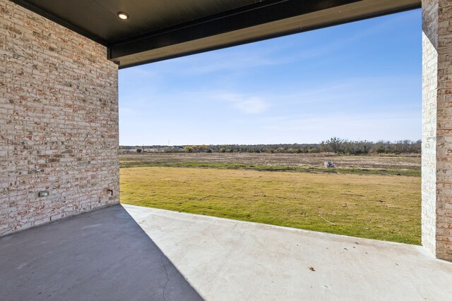 view of yard with a rural view and a patio