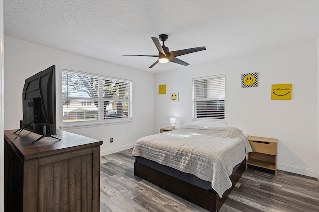 bedroom with a textured ceiling, dark hardwood / wood-style flooring, and ceiling fan