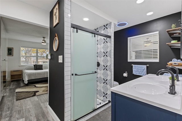 bathroom featuring an enclosed shower, wood-type flooring, vanity, and ceiling fan