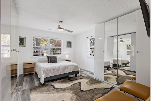 bedroom featuring ceiling fan, dark wood-type flooring, and a textured ceiling