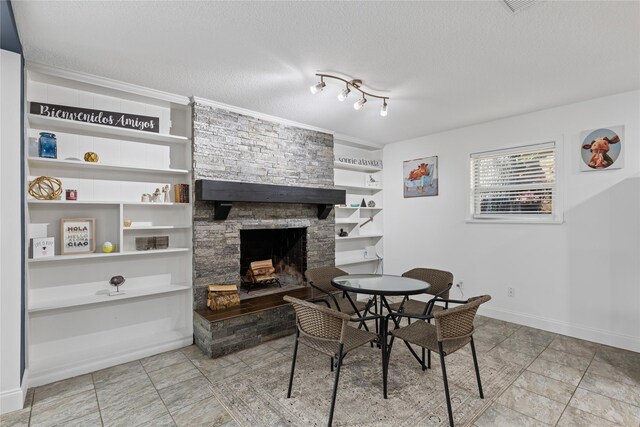 dining area with a stone fireplace and a textured ceiling